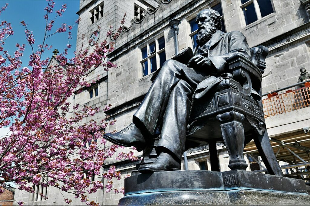 By Shrewsbury, Castle Gates: Charles Darwin statue in front of the library 3 by Michael Garlick, CC BY-SA 2.0, https://commons.wikimedia.org/w/index.php?curid=148454139
